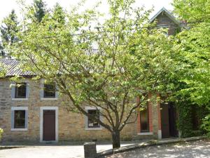 una casa de ladrillo con un árbol delante de ella en This plain house is very suitable for groups, en Ferrières