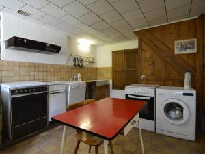cocina con mesa y lavadora en This plain house is very suitable for groups, en Ferrières
