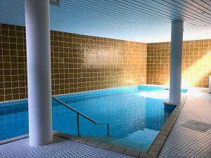 a swimming pool in a building with a tile wall at FeWo SeeLeben in Bodman-Ludwigshafen