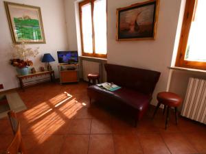 ein Wohnzimmer mit einem Ledersofa und einem TV in der Unterkunft Belvilla by OYO Casa Miralago in Magione