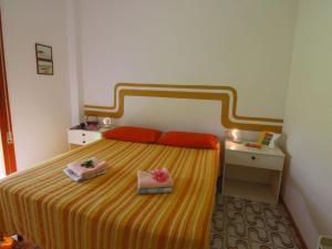 1 dormitorio con 1 cama con 2 toallas en Belvilla by OYO Il Girasole, en Principina a Mare