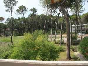 a park with a tree and some bushes and a building at Belvilla by OYO Il Girasole in Principina a Mare