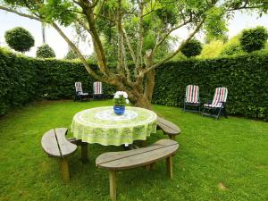 uma mesa e cadeiras num quintal com uma árvore em Independant Gite at the Calm way in the Center em Houffalize
