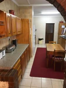 a kitchen with wooden cabinets and a table in it at Hawley House in Underberg