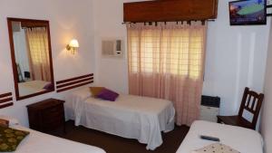 a room with two beds and a mirror at Hotel San Jorge in Paraná