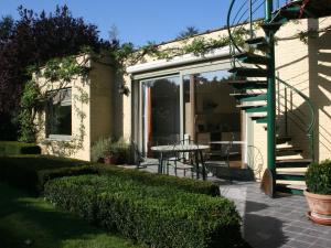 a house with a patio with a table and a staircase at Modern Holiday Home in Zingem with Garden in Zingem