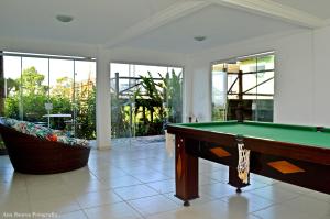 a living room with a pool table and a tub at Penedo House Pousada in Penedo