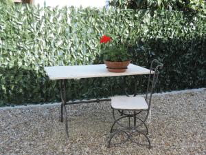 un tavolo e una sedia con un fiore sopra di Chiantirooms Guesthouse a Greve in Chianti