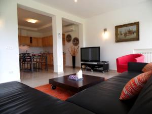 a living room with a black couch and a tv at Belvilla by OYO Varese Quattro in Comerio