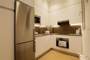 a kitchen with white cabinets and a stainless steel refrigerator at Jose Maria Soroa in San Sebastián