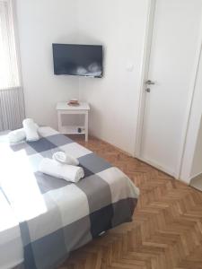 une chambre avec un lit et une télévision au mur dans l'établissement Apartment Nina, à Zadar
