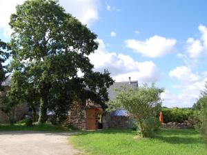 a house with a tree in front of it at Lovely mansion with fenced garden in Baguer-Morvan