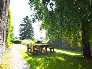ブイヨンにあるWonderful Holiday Home in Noirefontaine with Terrace Gardenの木の下の座卓と椅子2脚