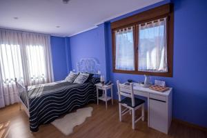 1 dormitorio con paredes azules, 1 cama y escritorio en Mendi Alai, en Carranza