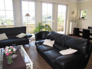 a living room with a black leather couch and a table at Holiday Home in Bouillon in Bouillon