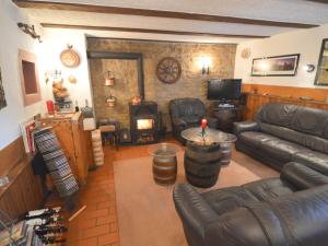 a living room with leather furniture and a fireplace at Holiday Home in Ittel with Balcony Heating BBQ Parking in Welschbillig