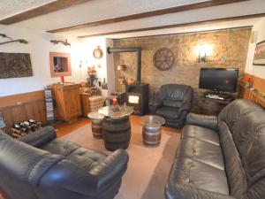 a living room with leather furniture and a flat screen tv at Holiday Home in Ittel with Balcony Heating BBQ Parking in Welschbillig