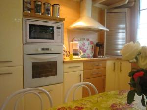 eine Küche mit einem Backofen und einem Tisch mit Stühlen in der Unterkunft Superb holiday home in Escalles near the sea in Escalles