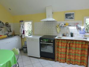 a kitchen with a stove and a counter top at Pleasant holiday home with garden in Isigny-le-Buat