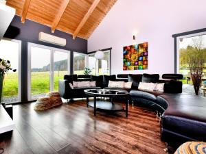 ein Wohnzimmer mit einem Sofa und einem Tisch in der Unterkunft Beautiful villa with heated outdoor pool in Manhay
