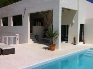 a villa with a swimming pool and a house at Belvilla by OYO Casa Loma in Cala Tarida