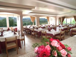 uma sala de jantar com mesas, cadeiras e flores em Hotel Belsol em Belmonte