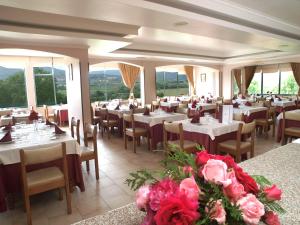 un comedor con mesas, sillas y flores en Hotel Belsol en Belmonte