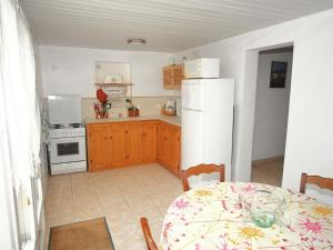 a kitchen with a table and a white refrigerator at Tranquil Holiday Home in Corsica with Terrace in Penta-di-Casinca