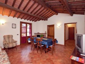 ein Wohnzimmer mit einem Tisch und Stühlen sowie einem TV in der Unterkunft Belvilla by OYO San Martino in Ambra
