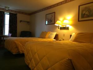 a hotel room with two beds and two lamps at Baxter Inn 4 Less in Baxter Springs