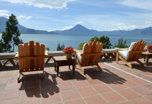 2 sillas y una mesa con vistas al agua en Hotel Casa Palopo en Santa Catarina Palopó