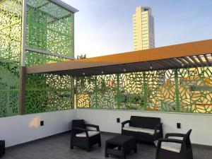 a building with chairs and a wall with stained glass at Herbal Inn Suites in Puebla