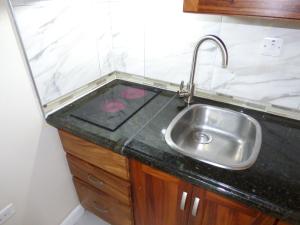 a kitchen with a sink and a black counter top at Beach Studio 6 in Ocho Rios