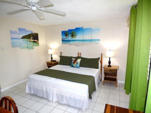 ein Schlafzimmer mit einem Bett, zwei Lampen und einem Ventilator in der Unterkunft Beach Studio 6 in Ocho Rios