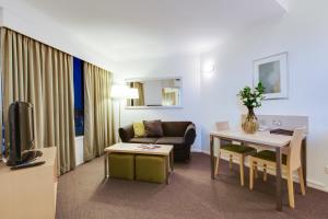 a living room filled with furniture and a tv at Oakwood Hotel & Apartments Brisbane in Brisbane