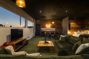 a living room with a couch and a tv at The Cinema Suites in Te Anau