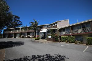 un aparcamiento vacío frente a un edificio en Molly Morgan Motor Inn, en Maitland