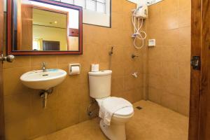 a bathroom with a toilet and a sink and a mirror at Levantin Boracay in Boracay