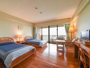 a hotel room with two beds and a flat screen tv at Pension Hoshinosuna in Iriomote