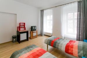 een woonkamer met 2 bedden en een televisie bij Apartament na Starówce in Bielsko-Biala