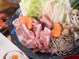 un plato de comida con carne y verduras. en Tokiwaso en Miyakonojō
