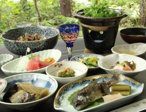 un tavolo con ciotole di cibo su un tavolo di Yokokura Ryokan a Nagano