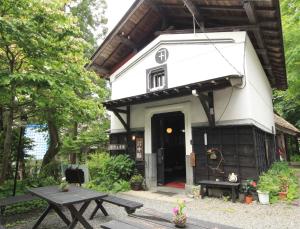 een klein huis met een picknicktafel ervoor bij Yokokura Ryokan in Nagano