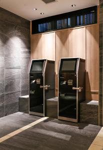 two elevators with their doors open in a restroom at Hotel Code Shinsaibashi in Osaka