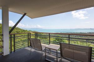 a balcony with two chairs and the ocean in the background at Mantra Samui Resort - Adults Only in Mae Nam