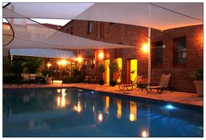 a swimming pool in front of a house at night at Mercure Hotel Mildura in Mildura