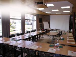 a classroom with tables and chairs and a white screen at Familiehotel Soll Cress Koksijde in Koksijde