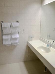 bagno con lavandino, specchio e asciugamani di Spa Hostel Kunnonpaikka a Kuopio