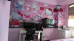 een kamer met een roze muur met hallo kitty stickers bij Fengchia Love Heart in Taichung