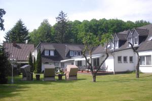 ein Haus mit ein paar Stühlen im Hof in der Unterkunft Parkhotel Phoenix Garni in Hage